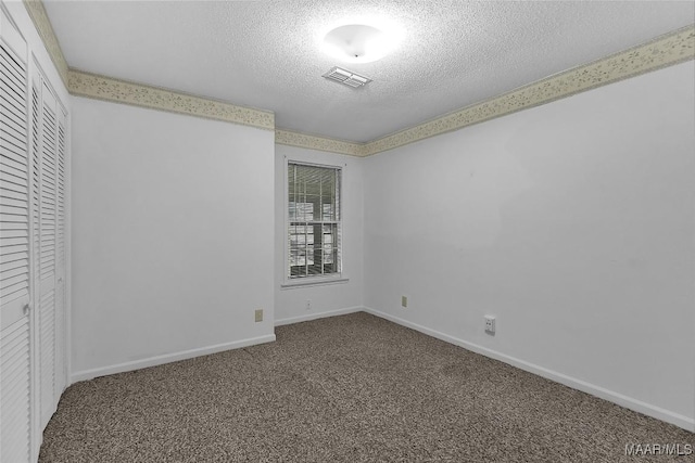 empty room with a textured ceiling and carpet flooring