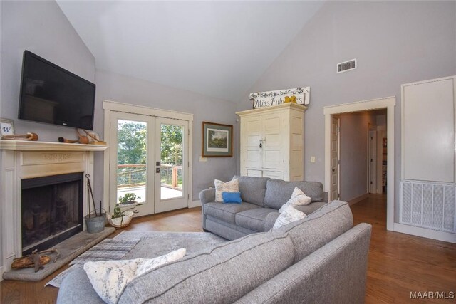 1086 Riverknolle Rd, Tallassee, AL 36078 - living area with french doors, wood finished floors, high vaulted ceiling, a fireplace with raised hearth, and visible vents