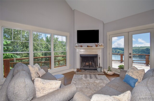 1086 Riverknolle Rd, Tallassee, AL 36078 - living area with a fireplace with raised hearth, high vaulted ceiling, plenty of natural light, and wood finished floors