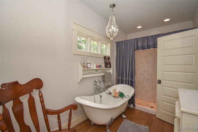 1086 Riverknolle Rd, Tallassee, AL 36078 - bathroom featuring an inviting chandelier, a walk in shower, a freestanding tub, and wood finished floors