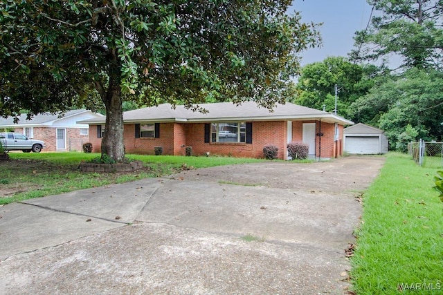 ranch-style home with brick siding, an outdoor structure, fence, driveway, and a front yard