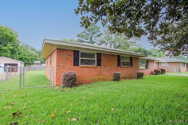 single story home featuring brick siding, a front lawn, fence, and a gate