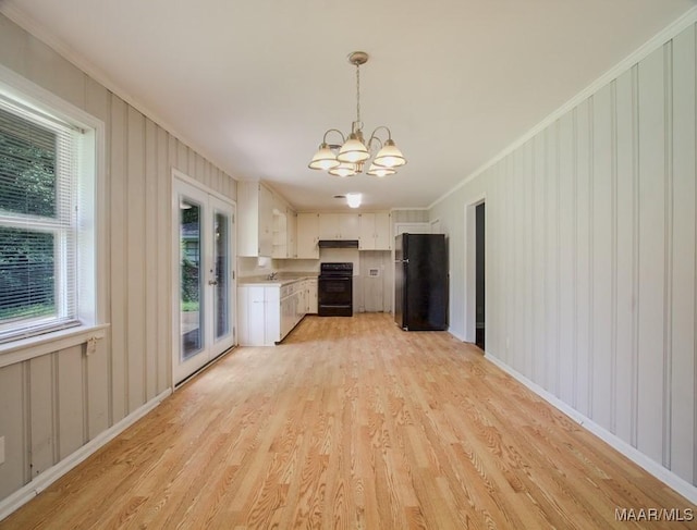 kitchen featuring ornamental molding, stove, freestanding refrigerator, an inviting chandelier, and light countertops