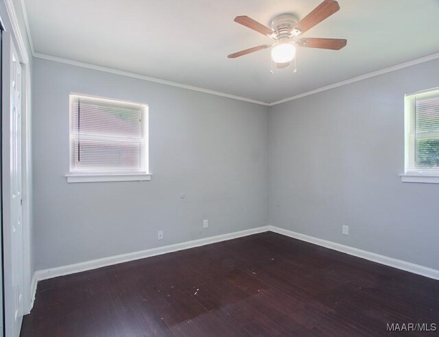 empty room with baseboards, ceiling fan, wood finished floors, and crown molding