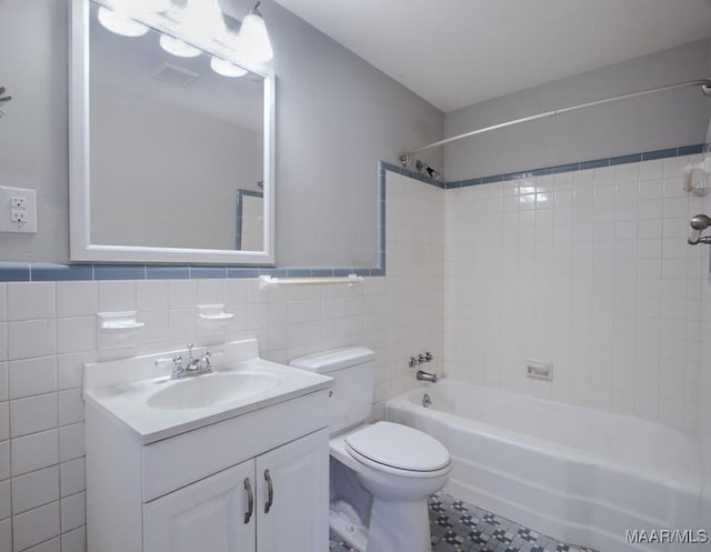 full bath featuring shower / washtub combination, tile walls, visible vents, toilet, and vanity