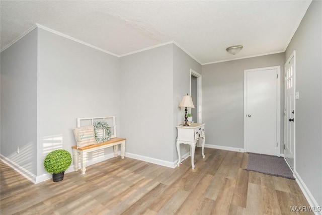 entryway featuring ornamental molding, a textured ceiling, and light hardwood / wood-style flooring