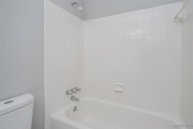 bathroom with tiled shower / bath combo and toilet