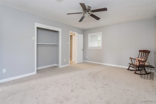 unfurnished room featuring a textured ceiling, ceiling fan, and light carpet