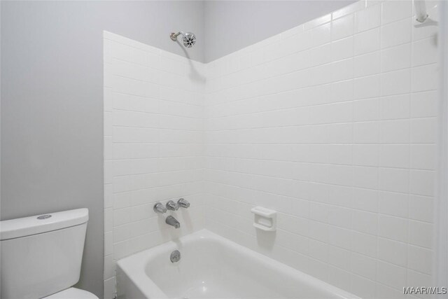 bathroom with toilet and tiled shower / bath