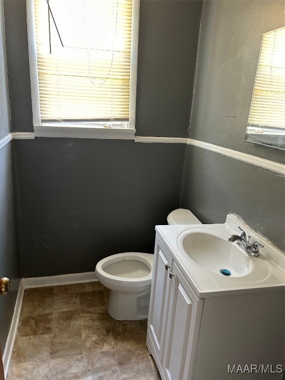 bathroom featuring toilet, tile patterned floors, vanity, and plenty of natural light