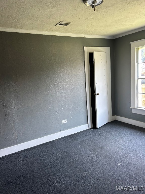 unfurnished bedroom with a textured ceiling and carpet floors