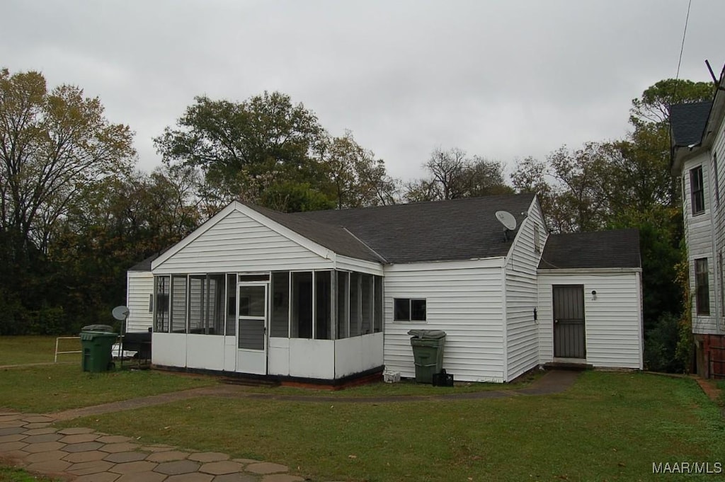 back of house with a sunroom and a yard