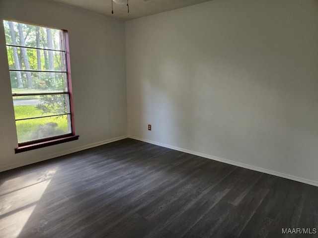 empty room with dark wood finished floors and baseboards