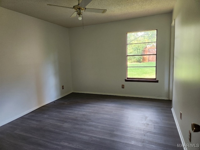 spare room featuring ceiling fan, dark wood-style flooring, a textured ceiling, and baseboards