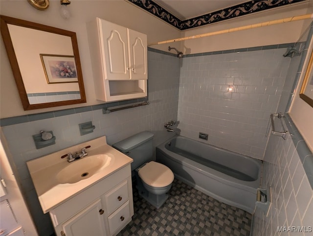 full bathroom featuring tasteful backsplash, toilet, tiled shower / bath, tile walls, and vanity