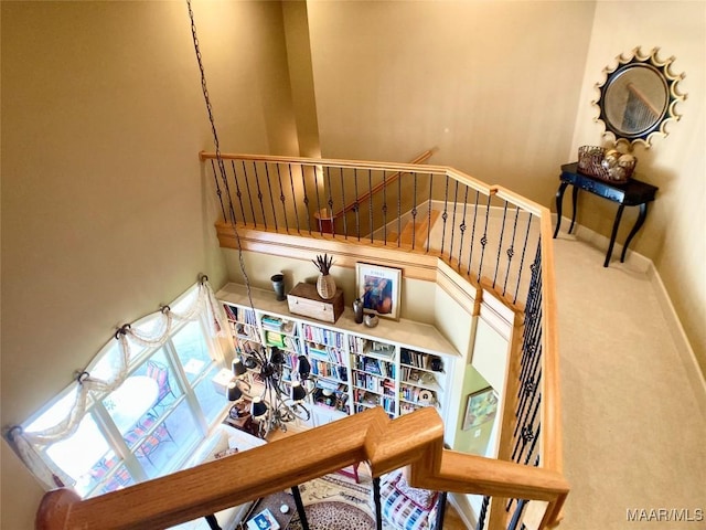 stairway with baseboards and carpet flooring