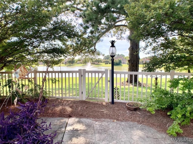 view of yard featuring a water view and fence