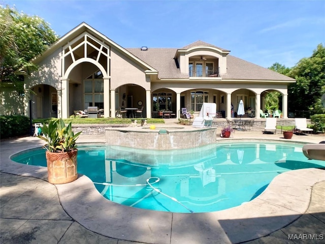 outdoor pool with a water slide and a patio area