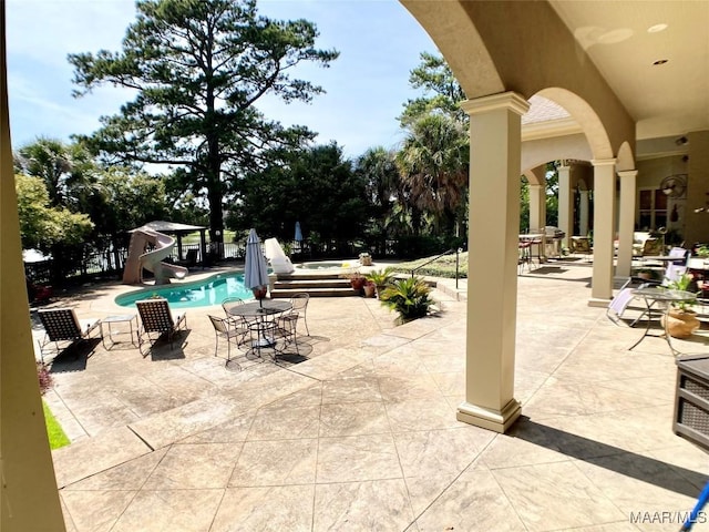 pool featuring a water slide and a patio