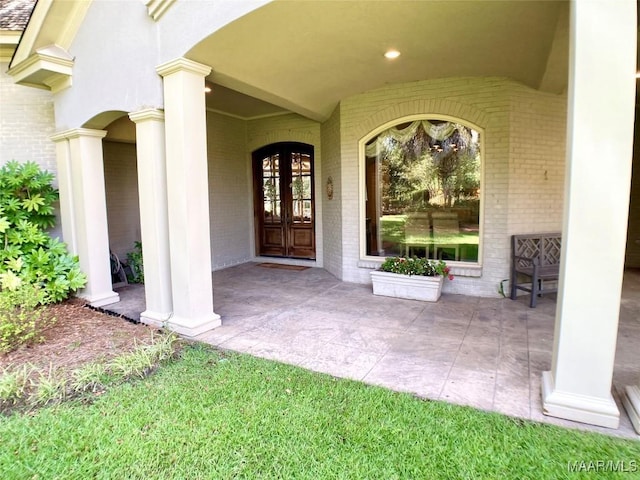 entrance to property featuring french doors and brick siding
