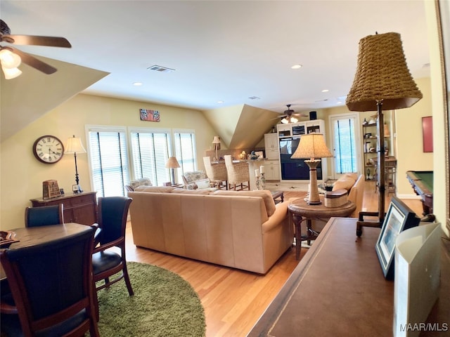 living room featuring vaulted ceiling, ceiling fan, and light hardwood / wood-style floors