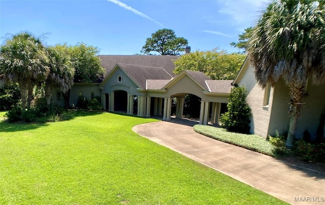 view of front of house featuring a shingled roof, a front yard, and stucco siding