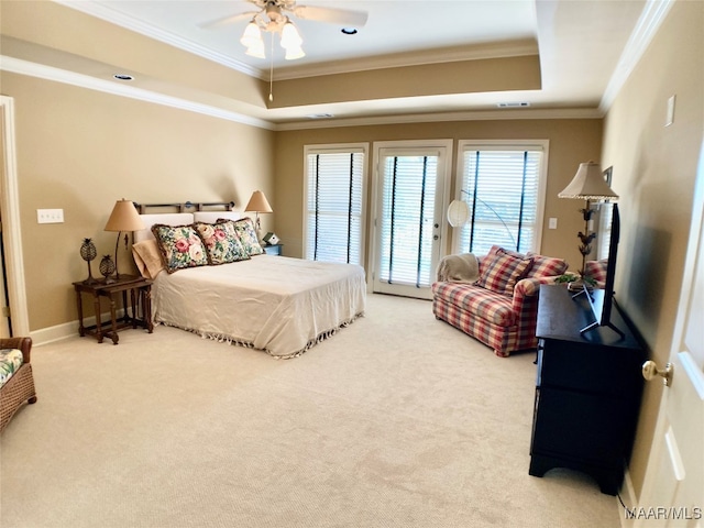 carpeted bedroom featuring ceiling fan, ornamental molding, and a tray ceiling