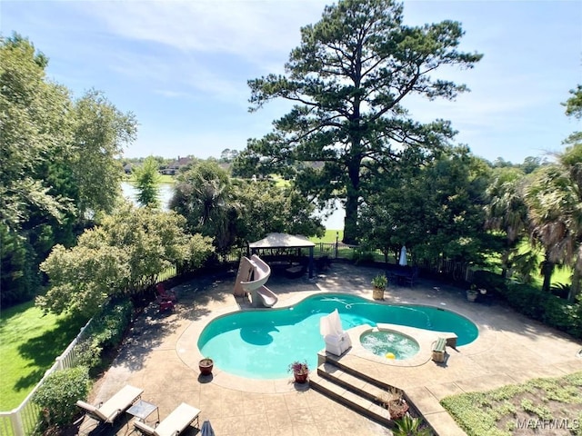 view of swimming pool with fence, a pool with connected hot tub, a water slide, a patio, and a gazebo