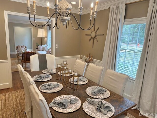 dining room with an inviting chandelier, ornamental molding, and hardwood / wood-style flooring