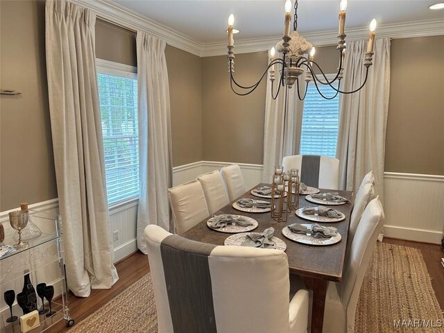 dining space featuring crown molding, hardwood / wood-style floors, and an inviting chandelier