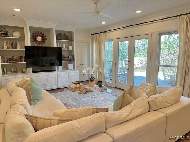 living room with ceiling fan, crown molding, french doors, and built in shelves