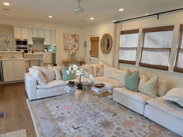 living room with ceiling fan, hardwood / wood-style flooring, and crown molding