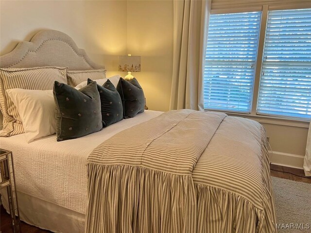 bedroom featuring multiple windows and hardwood / wood-style flooring