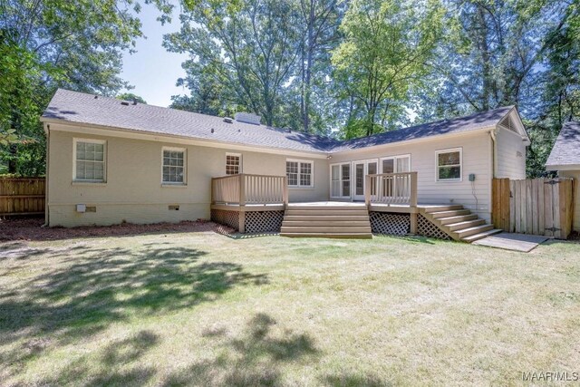 rear view of house with a yard and a wooden deck