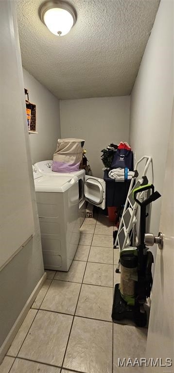 laundry room with light tile patterned flooring, a textured ceiling, and independent washer and dryer