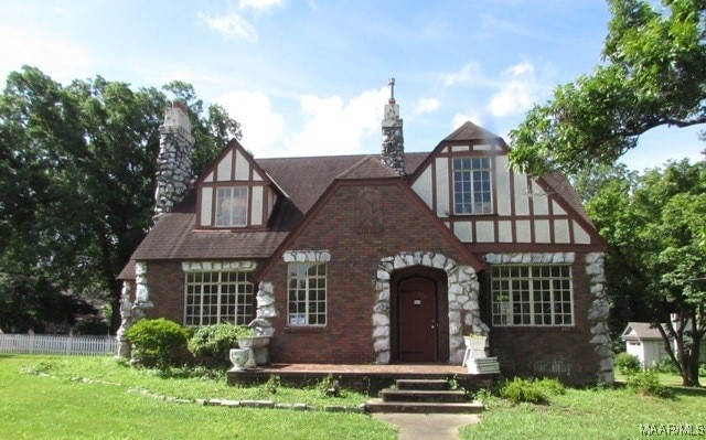 tudor home featuring a front lawn