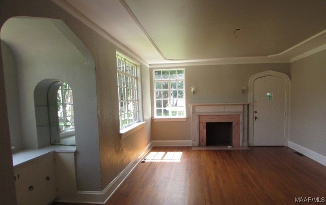 unfurnished living room with a fireplace, ornamental molding, and hardwood / wood-style floors