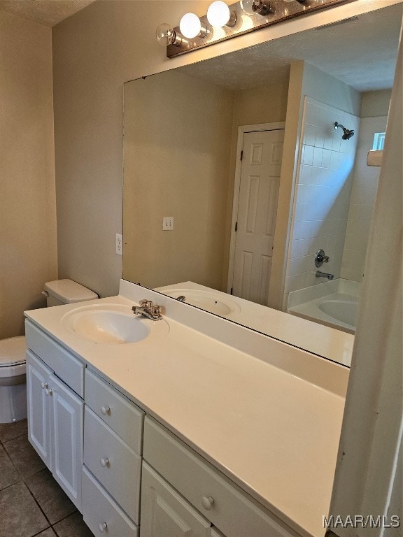 full bathroom featuring tile patterned floors, tiled shower / bath combo, vanity, and toilet