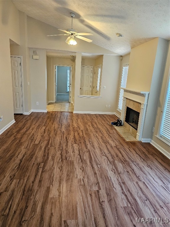 unfurnished living room featuring a fireplace, vaulted ceiling, and light hardwood / wood-style floors