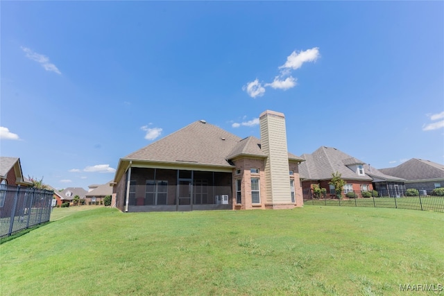 rear view of property featuring a sunroom and a yard