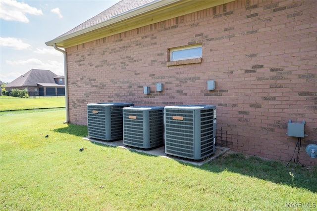 view of side of home featuring central AC unit and a yard