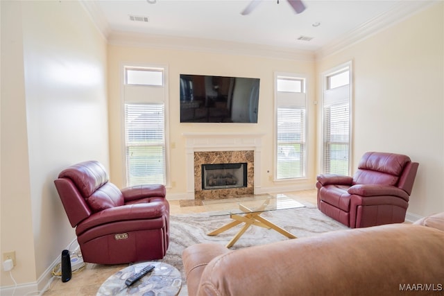 tiled living room featuring a fireplace, ceiling fan, and crown molding