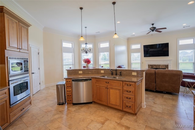 kitchen featuring ornamental molding, stainless steel appliances, sink, and decorative light fixtures