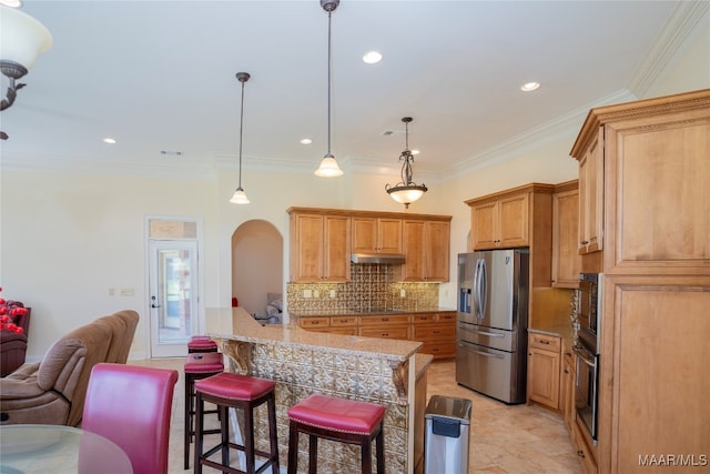 kitchen featuring pendant lighting, stainless steel appliances, and ornamental molding