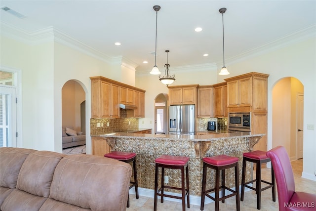 kitchen featuring ornamental molding, appliances with stainless steel finishes, decorative light fixtures, and tasteful backsplash