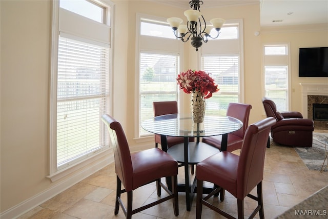 dining area with a fireplace, plenty of natural light, crown molding, and an inviting chandelier