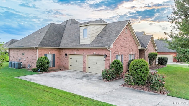 property exterior at dusk featuring a garage, cooling unit, and a lawn