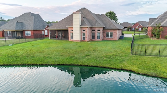 rear view of house featuring a sunroom and a yard