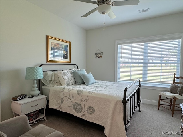 carpeted bedroom with multiple windows and ceiling fan