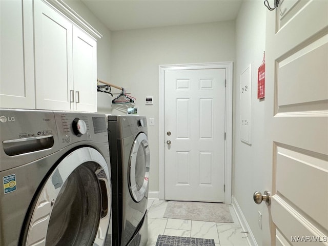 laundry area featuring light tile patterned flooring, separate washer and dryer, and cabinets